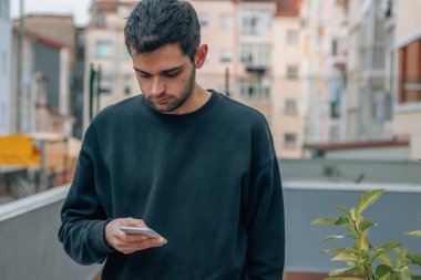 Adam elinde cep telefonuna bakıyor.