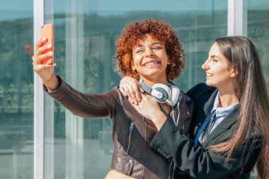 girls recording with mobile phone or taking photos on the street outdoors