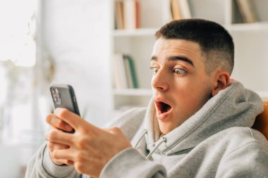 Evde cep telefonuna ya da akıllı telefona bakan çocuk şaşırdı.