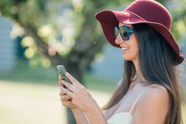 young girl chatting with mobile phone outdoors