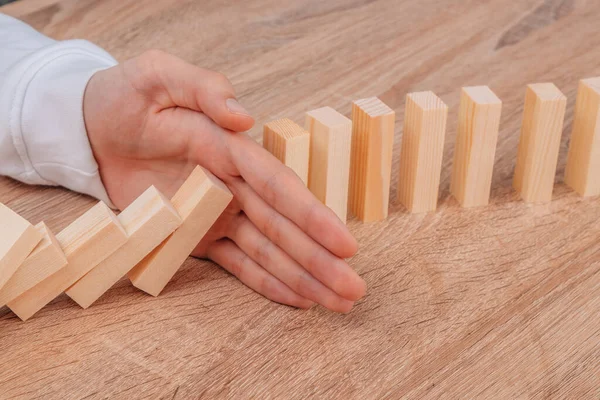 Hand Stops Falling Dominoes Wooden Puzzle — Foto de Stock