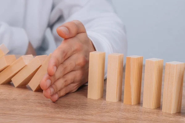 Hand Stops Falling Dominoes Wooden Puzzle — Foto de Stock