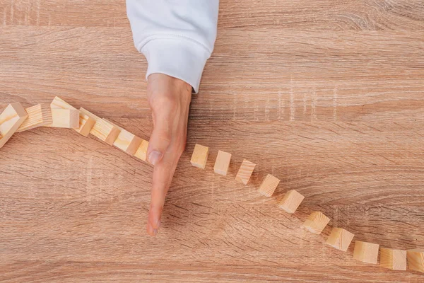 Hand Stops Falling Dominoes Wooden Puzzle — 스톡 사진
