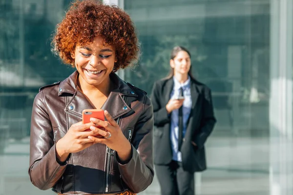 urban african american girl with mobile phone in the street