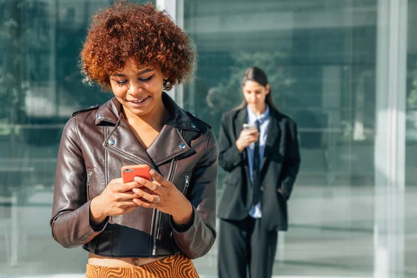 urban african american girl with mobile phone in the street