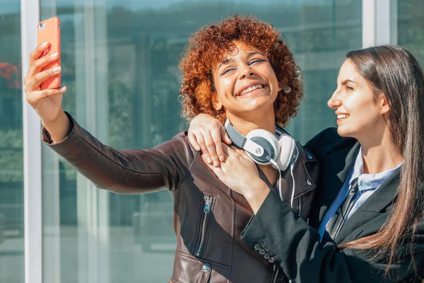 girls recording with mobile phone or taking photos on the street outdoors