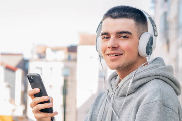Νεαρός Άνδρας Κινητό Τηλέφωνο Και Ακουστικά Ακούγοντας Μουσική — Φωτογραφία Αρχείου