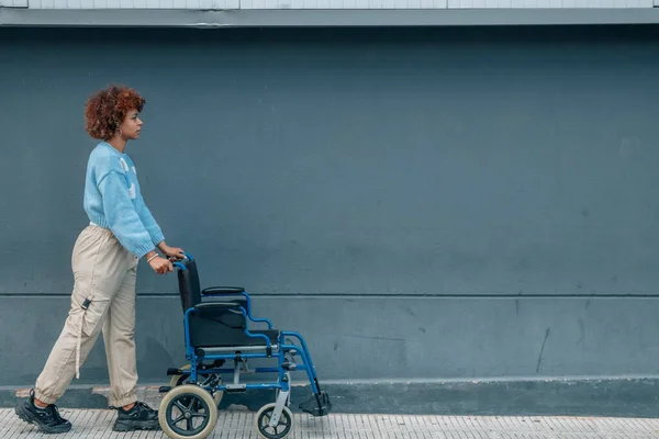 Girl Street Pushing Wheelchair — Stockfoto