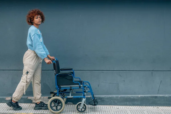 African American Girl Pushing Wheelchair — Stok fotoğraf