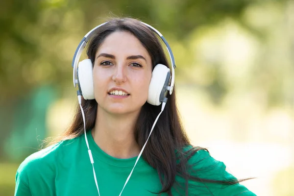 屋外で音楽を聴くヘッドフォン少女 — ストック写真