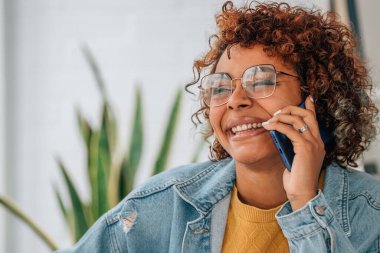 Cep telefonuyla konuşan Afrikalı Amerikalı bir kızın portresi.
