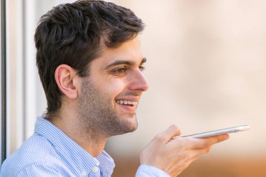Cep telefonlu genç adam sesli mesaj gönderiyor.