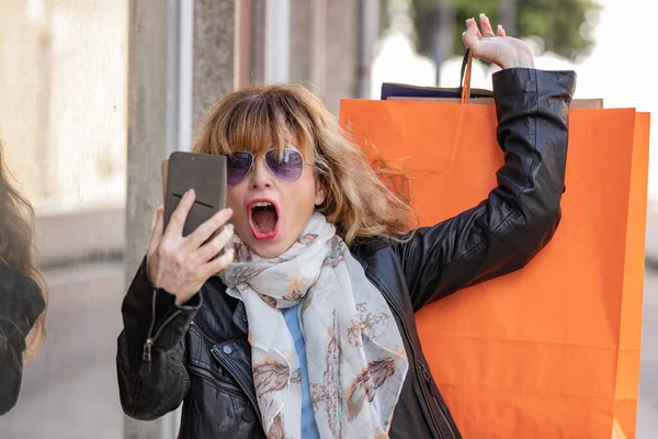 Middle Aged Woman Street Shopping Bags Mobile Phone Surprised Expression — Stockfoto