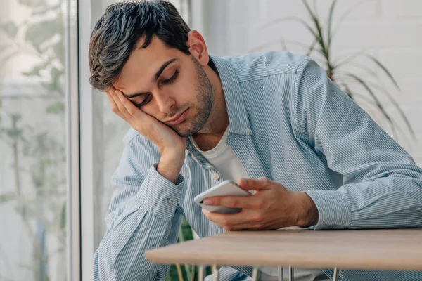 Young Man Home Bored Looking Mobile Phone — Stockfoto