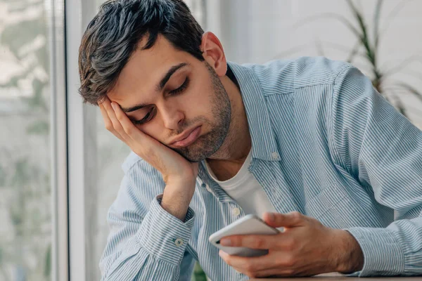 Young Man Home Bored Looking Mobile Phone — Stock fotografie