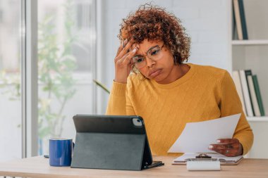 Evde dizüstü bilgisayarı olan stresli bir kız var.