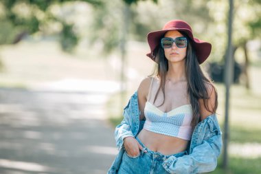 urban hipster girl in hat and sunglasses in summer on the street
