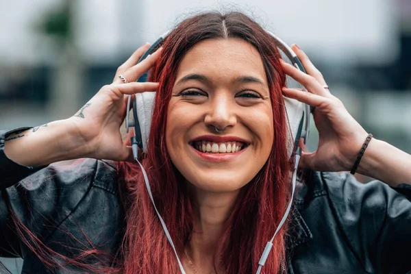 女性は音楽を聴くヘッドフォンで笑顔で — ストック写真
