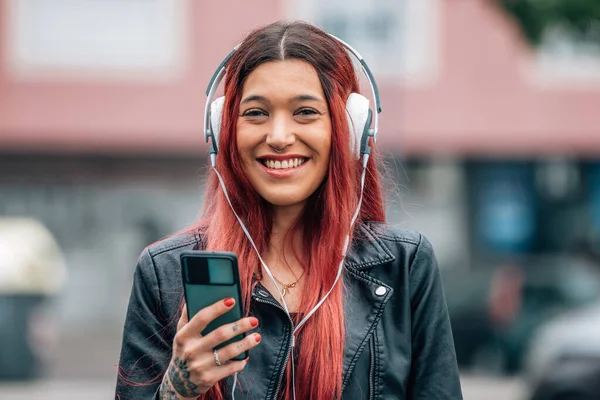 Χαμογελαστό Νεαρό Κορίτσι Ακουστικά Και Κινητό Τηλέφωνο — Φωτογραφία Αρχείου