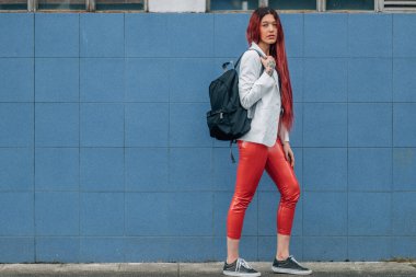 Kızıl saçlı kız sokaklarda mutlu mesut yürüyor.