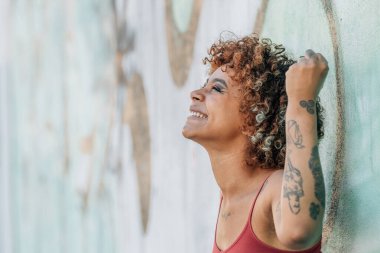 Kız yazın sokakta mutlu bir şekilde gülümsüyor.