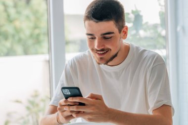 Cep telefonlu genç adam sohbet ediyor ya da oyun oynuyor