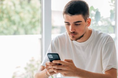 Cep telefonlu genç adam sohbet ediyor ya da oyun oynuyor