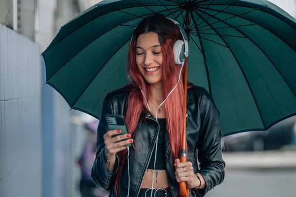 Κοκκινομάλλα Κορίτσι Κινητό Τηλέφωνο Και Ακουστικά Στο Δρόμο Ομπρέλα — Φωτογραφία Αρχείου