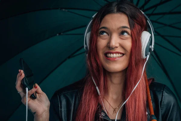 Porträtt Rödhårig Flicka Med Mobiltelefon Och Hörlurar Med Paraply — Stockfoto