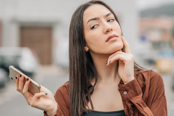 Menina Com Telefone Celular Expressão Desconfiada — Fotografia de Stock