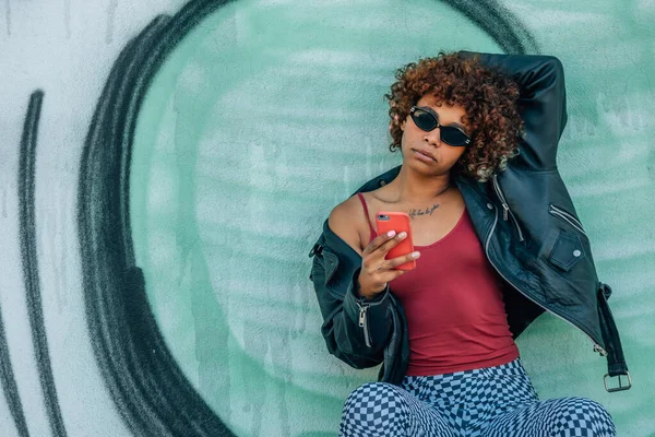 Sokaktaki Duvarda Cep Telefonu Akıllı Telefonu Olan Şehir Kızı — Stok fotoğraf