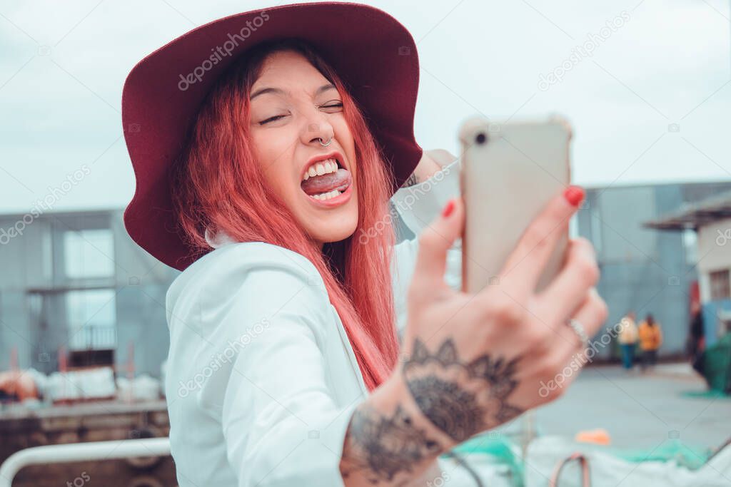 redhead influencer with mobile phone recording or taking photo