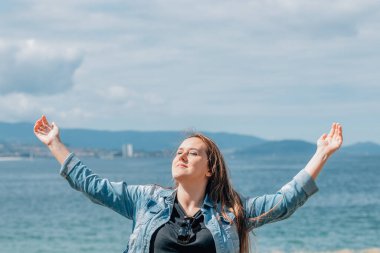 Kadın plajda güneşin tadını çıkarıyor.