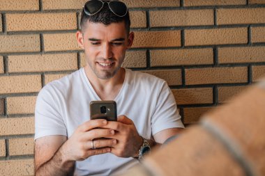 Cep telefonu olan orta yaşlı genç bir adam.