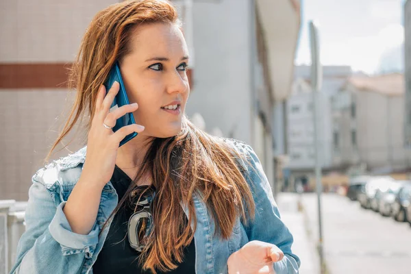 middle-aged woman in the street talking on a mobile phone or cell phone