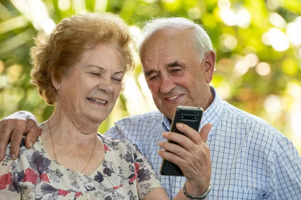 happy grandparents or senior couple with mobile phone