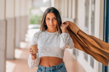 latin girl in the street in fashion with the jacket in the wind