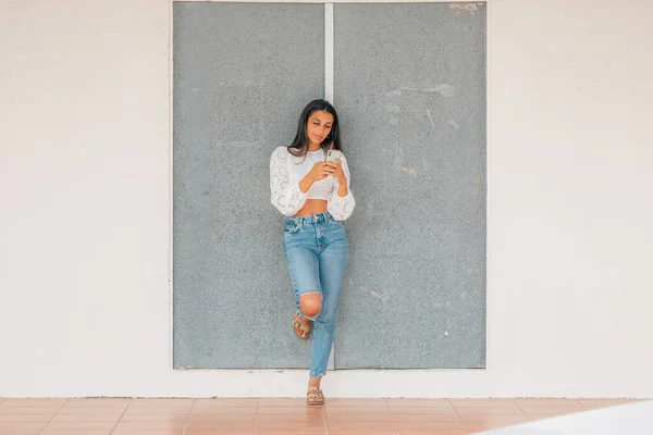 Menina Latina Parede Com Telefone Móvel — Fotografia de Stock