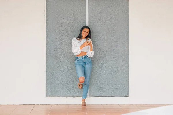 Menina Latina Parede Com Telefone Móvel — Fotografia de Stock