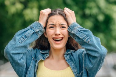 Açık havada tiksinti ifadesi olan bir kız.