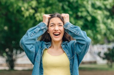 Açık havada tiksinti ifadesi olan bir kız.