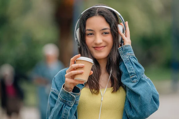Κορίτσι Στο Δρόμο Ακούγοντας Μουσική Ακουστικά Και Ένα Φλιτζάνι Καφέ — Φωτογραφία Αρχείου