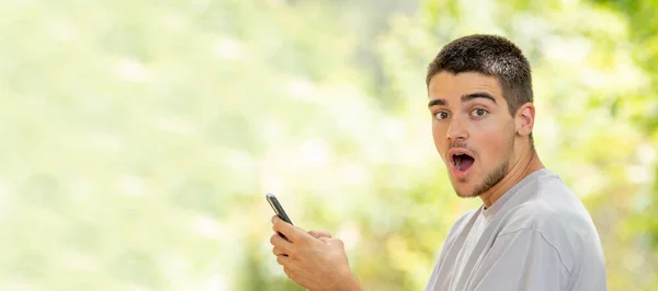 Young Man Mobile Cell Phone Outdoors Surprised Expression — Stock Photo, Image