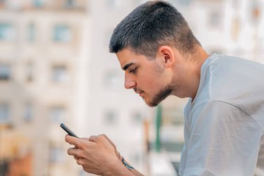 Şehirde cep telefonu ve cep telefonu olan genç bir adam.