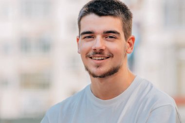 Açık havada sakallı beyaz bir gencin portresi.