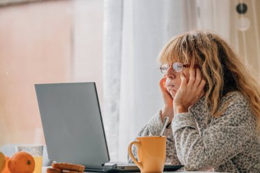 Evde bilgisayarı olan orta yaşlı bir kadın