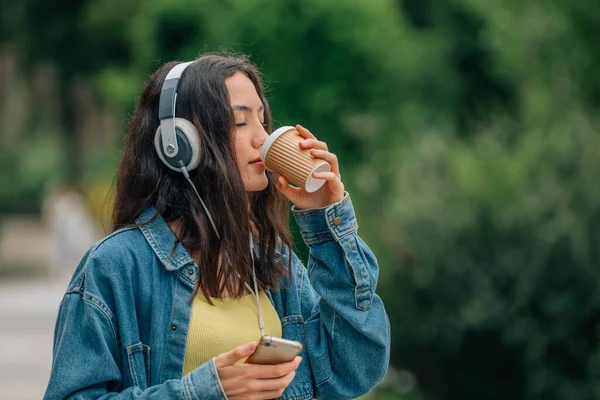 Κορίτσι Στο Δρόμο Κινητό Τηλέφωνο Και Ακουστικά Και Φλιτζάνι Καφέ — Φωτογραφία Αρχείου