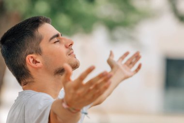 Genç adam dışarıda rahatça nefes alıyor.