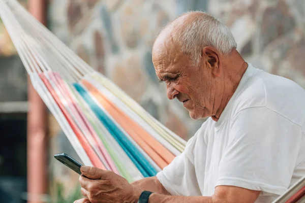 Пожилой Мужчина Смотрит Мобильный Телефон — стоковое фото
