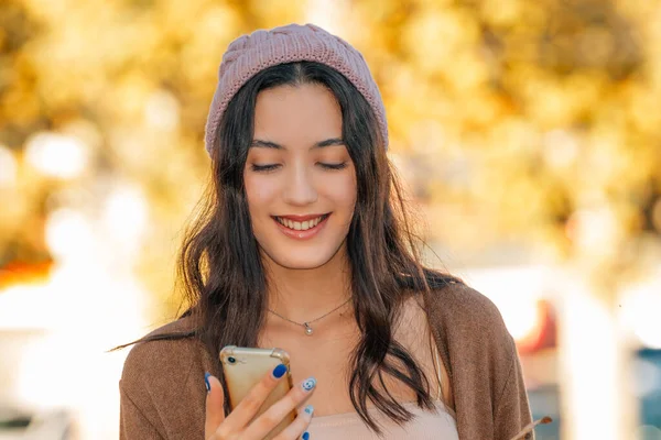 Menina Sorrindo Olhando Para Telefone Móvel Outono — Fotografia de Stock